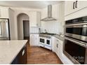 Modern kitchen features stainless steel appliances, a stylish range hood, and white cabinetry at 12508 Asbury Chapel Rd, Huntersville, NC 28078
