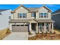 Beautiful two-story home with a gray garage door, brick accents, and a welcoming entryway at 13729 Roderick Dr # 188, Huntersville, NC 28078