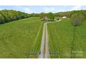 Long driveway leading to a beautiful home with expansive green fields at 16160 Hopewell Church Rd, Midland, NC 28107
