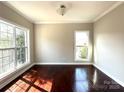 Bright living room featuring gleaming hardwood floors and abundant natural light through two large windows at 16446 Doves Canyon Ln, Charlotte, NC 28278