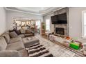 Open-concept living room featuring a modern fireplace, plush gray sectional, and sleek, gray flooring at 1916 Pegram St, Charlotte, NC 28205