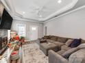 Spacious living room featuring tray ceilings, a ceiling fan, plush sectional, and neutral decor at 1916 Pegram St, Charlotte, NC 28205