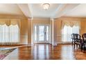 Elegant entryway featuring hardwood floors, decorative columns, and a glass-paneled front door at 2689 Wingrave Nw St, Concord, NC 28027