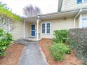 Charming home entrance with covered porch, quaint windows, and landscaped greenery at 2727 Tiergarten Ln, Charlotte, NC 28210