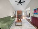 Spacious living room with vaulted ceilings, brick fireplace, and access to dining area at 2727 Tiergarten Ln, Charlotte, NC 28210