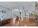 Open-concept living area with hardwood floors, archways, and a view into the adjacent dining room and kitchen at 3173 Delaware Dr, Denver, NC 28037