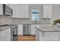 Bright kitchen featuring stainless steel appliances, granite countertops, and white cabinets with modern hardware at 318 Lewis Ferry Rd, Statesville, NC 28677