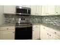 Well-lit kitchen featuring stainless steel appliances, granite counters, and stylish backsplash at 404 N Laurel Ave # 28, Charlotte, NC 28204