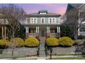 Beautiful two-story home with a welcoming front porch, well-kept landscaping, and a stone stairway leading to the entrance at 415 Vintage Hill Ln, Huntersville, NC 28078