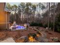 View of a backyard with a pool, patio, and surrounding trees from the rear of the house at 4893 River Hills Dr, Denver, NC 28037