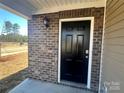 Close-up of a home's front door with brick surround and stylish exterior lighting at 588 N Sparkleberry Ln, Chester, SC 29706