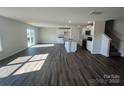 Open-concept living room flowing into a modern kitchen with hardwood floors and plenty of natural light at 588 N Sparkleberry Ln, Chester, SC 29706