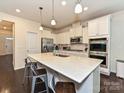 Modern kitchen featuring a large island, stainless steel appliances and pristine white cabinetry at 7015 Walnut Branch Ln, Charlotte, NC 28277