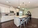 Bright kitchen with stainless appliances, white cabinets, and an expansive island with bar stool seating at 7015 Walnut Branch Ln, Charlotte, NC 28277