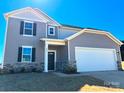 Charming gray two-story home featuring a well-manicured lawn and stone accents at 705 Hallman Branch Ln, Lincolnton, NC 28092