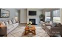 Cozy living room featuring a fireplace, neutral tones, large windows, and comfortable seating at 8055 Hereford St, Charlotte, NC 28213