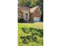 Beautiful brick home featuring an attached two car garage, and green lawn at 8731 Sheltonham Way, Charlotte, NC 28216