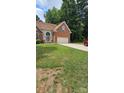 Charming brick home with an attached two car garage and a well manicured green lawn at 8731 Sheltonham Way, Charlotte, NC 28216