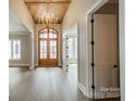 Elegant foyer features a stunning wood ceiling, hardwood floors, and a grand chandelier, creating a welcoming entrance at 102 Pecan Cove Ln, Weddington, NC 28104