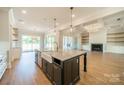 Gorgeous kitchen island with farmhouse sink, marble countertops, and pendant lighting at 102 Pecan Cove Ln, Weddington, NC 28104