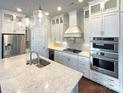 Gourmet kitchen with stainless steel appliances, a large island and pendant lighting at 11005 Cobb Creek Ct, Charlotte, NC 28277