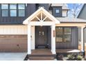 Inviting front porch with wooden deck, white columns, and a modern front door at 119 Mills Garden Rd, Statesville, NC 28625