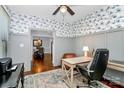 Inviting home office featuring a ceiling fan, hardwood floors, cozy furniture and decorative wallpaper at 126 Anchor Ln, Troutman, NC 28166