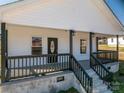 Inviting front porch with black railings and support beams frames a decorative front door at 1411 Roseland Dr, Lincolnton, NC 28092