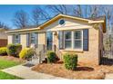 View of a charming brick house with blue shutters and well-maintained landscaping at 1438 Plumstead Rd, Charlotte, NC 28216