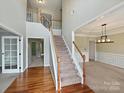 Spacious foyer featuring hardwood floors, a staircase, and an open view of the dining room at 1580 Duckhorn Nw St, Concord, NC 28027