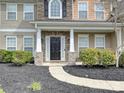 Elegant front entrance featuring stone accents, white columns, and a well-maintained landscape at 1580 Duckhorn Nw St, Concord, NC 28027