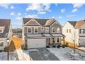 An attractive two-story home with gray siding, stone accents, a two-car garage, and a well-maintained front yard at 163 W Heart Pine Ln # 51, Statesville, NC 28677