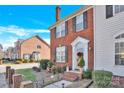 Charming red brick townhome with manicured lawn, black shutters, and a welcoming front entrance with a festive wreath at 17614 Delmas Dr, Cornelius, NC 28031