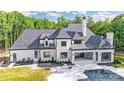 Expansive backyard with a modern patio, outdoor kitchen, covered patio, and sparkling in-ground pool at 211 Sugar Maple Ln, Weddington, NC 28104