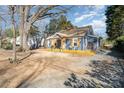 Charming home with a covered front porch, lovely blue exterior and nicely kept grounds at 2137 Highland St, Charlotte, NC 28208