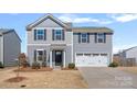 Two-story home with gray siding, black shutters, two car garage, and a well-maintained lawn at 2462 Willow Pond Se Ln, Concord, NC 28025