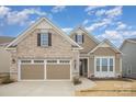 Charming brick and siding home featuring a well-manicured lawn and an attached two-car garage at 4018 Moxie Way, Charlotte, NC 28215