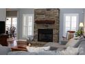 Cozy living room featuring a stone fireplace, hardwood floors, and a comfortable seating area at 522 Sarazen Way, Salisbury, NC 28144