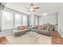 Bright living room featuring hardwood floors, a ceiling fan, and large windows at 554 Amalfi Dr, Davidson, NC 28036