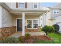 Inviting front porch with stone accents, columns, and a well-maintained garden at 6635 Ruth Ferrell Ct, Charlotte, NC 28269