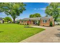 Beautiful brick home showcasing a lush green lawn and a well-maintained exterior with mature trees at 905 Blalock Dr, Kings Mountain, NC 28086
