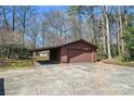 Detached brown garage with carport and concrete drive providing ample parking and storage space at 10007 Mountain Apple Dr, Mint Hill, NC 28227