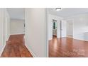 Bright hallway with wood floors and white walls providing a transition to the adjacent rooms at 10007 Mountain Apple Dr, Mint Hill, NC 28227
