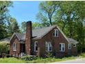 Classic brick home showcasing a sturdy chimney and traditional architecture, surrounded by lush greenery at 107 Lineberger St # 6, Shelby, NC 28150