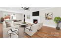 Cozy living room with a fireplace, hardwood floors, and a ceiling fan at 1121 S Edgemont Ave, Gastonia, NC 28054