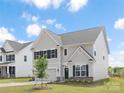 Beautifully landscaped home with green lawn, attached garage, and architectural details at 122 Asmodean Ln, Troutman, NC 28166