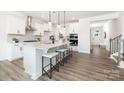 Modern kitchen with white cabinets, quartz countertops, stainless steel appliances, and a large island at 122 Asmodean Ln, Troutman, NC 28166