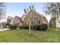 Landscaped yard surrounds a brick house with black shutters and a well maintained lawn at 12430 Kemerton Ln # 17, Huntersville, NC 28078