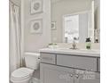 Stylish bathroom featuring a modern vanity, ample mirror, and a shower with a neutral-toned curtain at 128 Asmodean Ln, Troutman, NC 28166