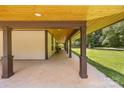 Spacious covered porch with wooden ceiling beams and ample seating area at 13124 Lemmond Dr, Matthews, NC 28105